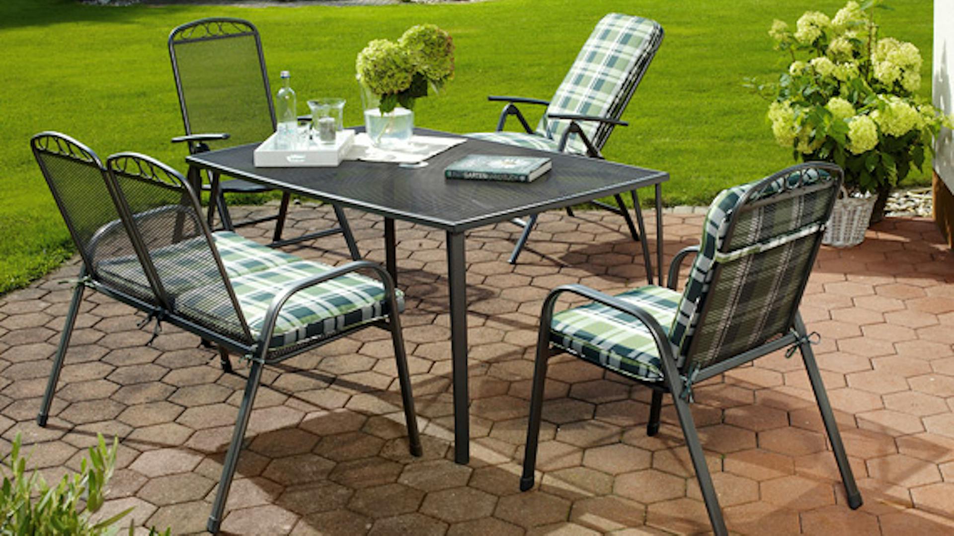 Vas és acél kerti bútorok egy kertben