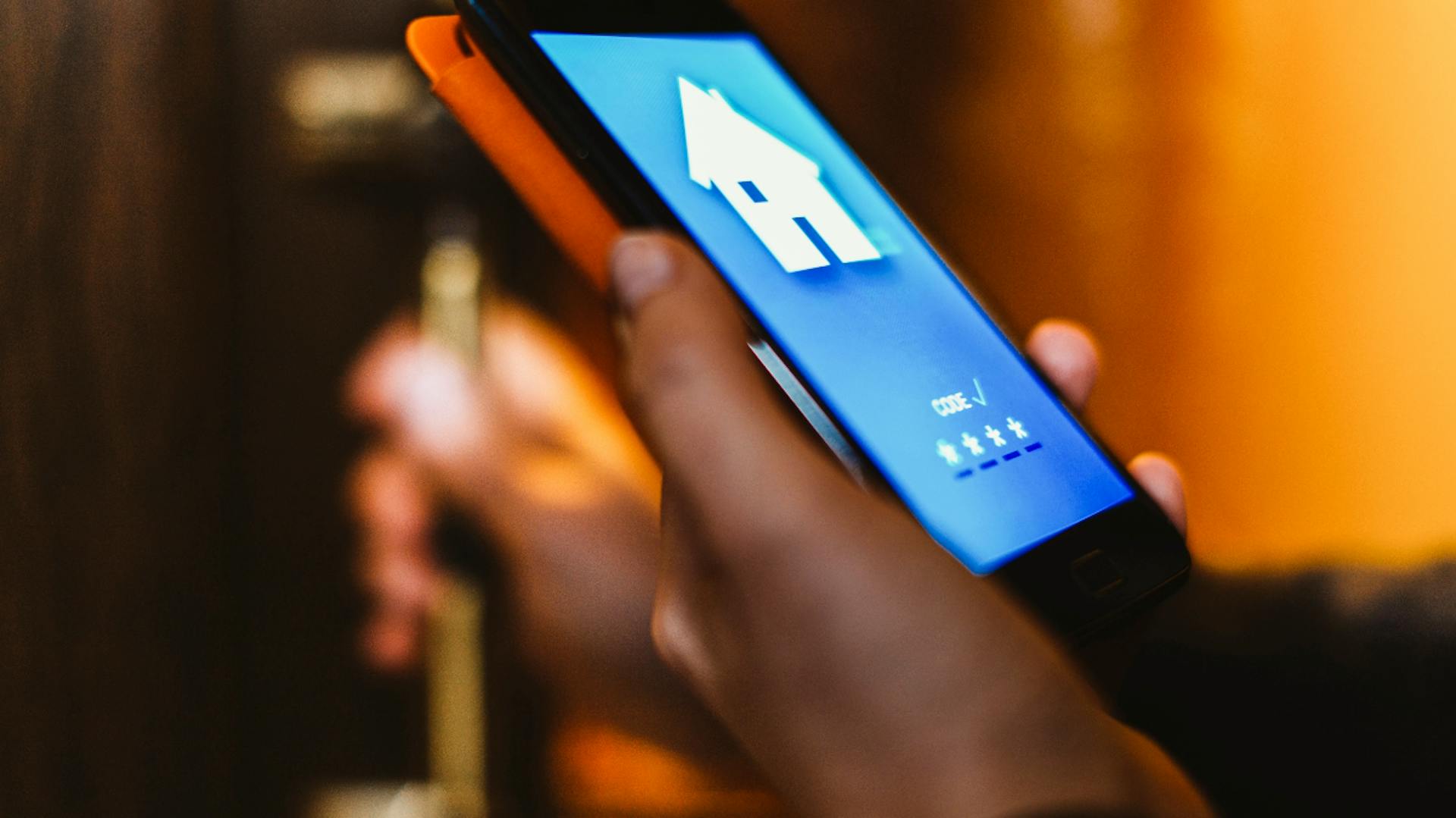 persona gestisce dispositivi di sicurezza dal telefono