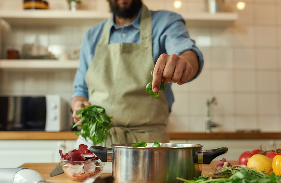uomo utilizza basilico in cucina
