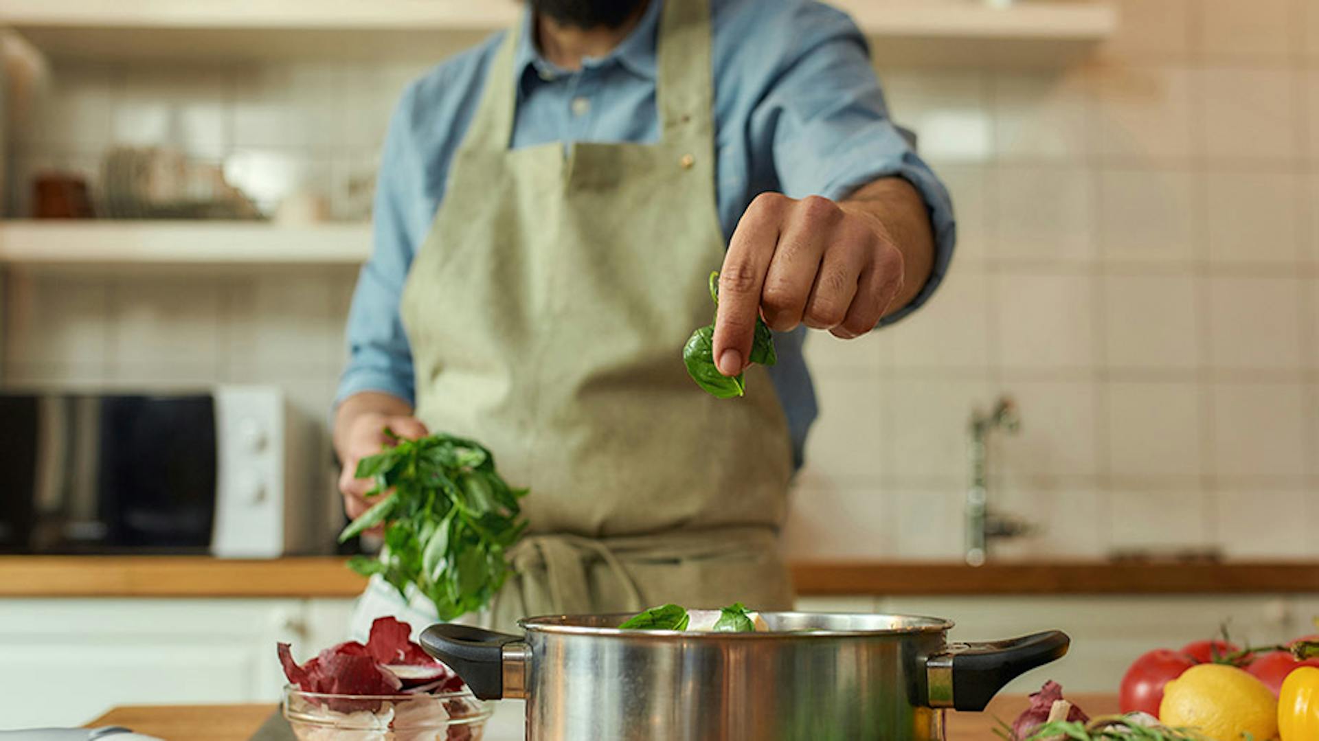 uomo utilizza basilico in cucina