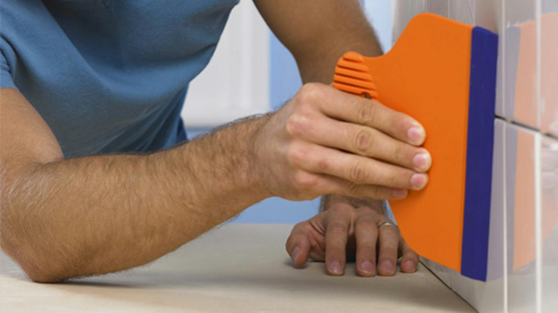 uomo lavora le fughe delle piastrelle