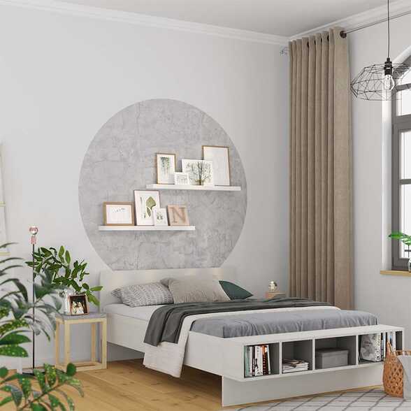 Ein Schlafzimmer mit Bett, über dem ein runder Kreis aus Vliestapete an die Wand geklebt wurde.