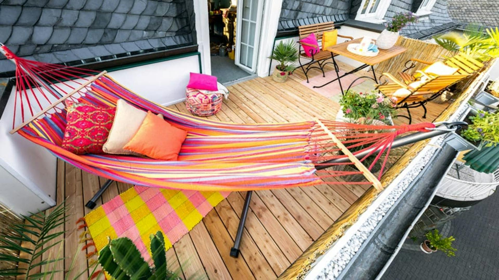 Neugestalteter Balkon mit Holzdielen, Hängematte und Sitzecke