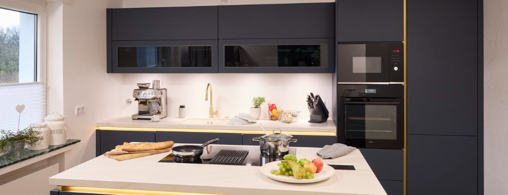 Küche mit Kücheninsel und schwarzen Fronten