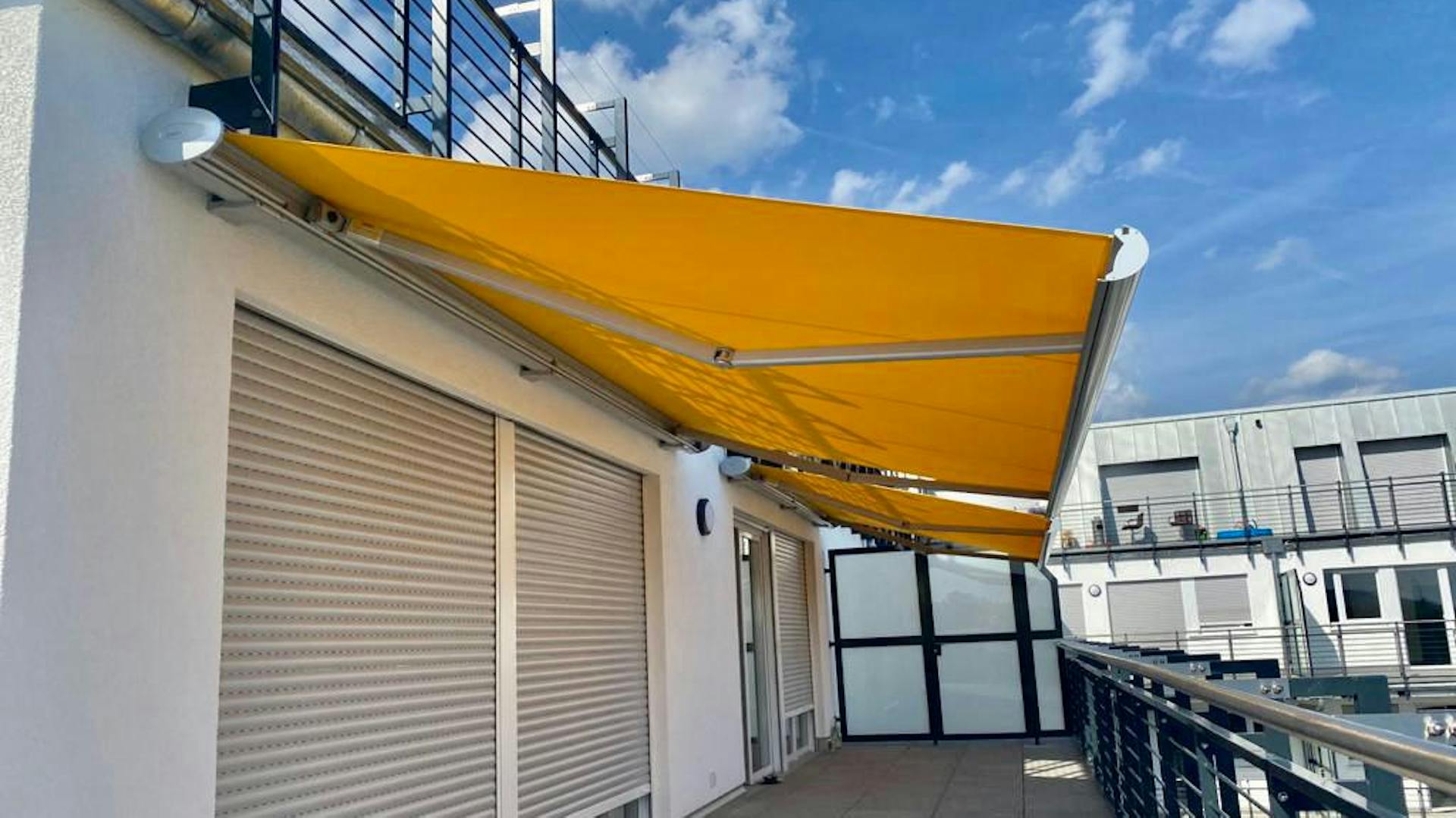 Orangene Markise an einem Balkon ausgefahren