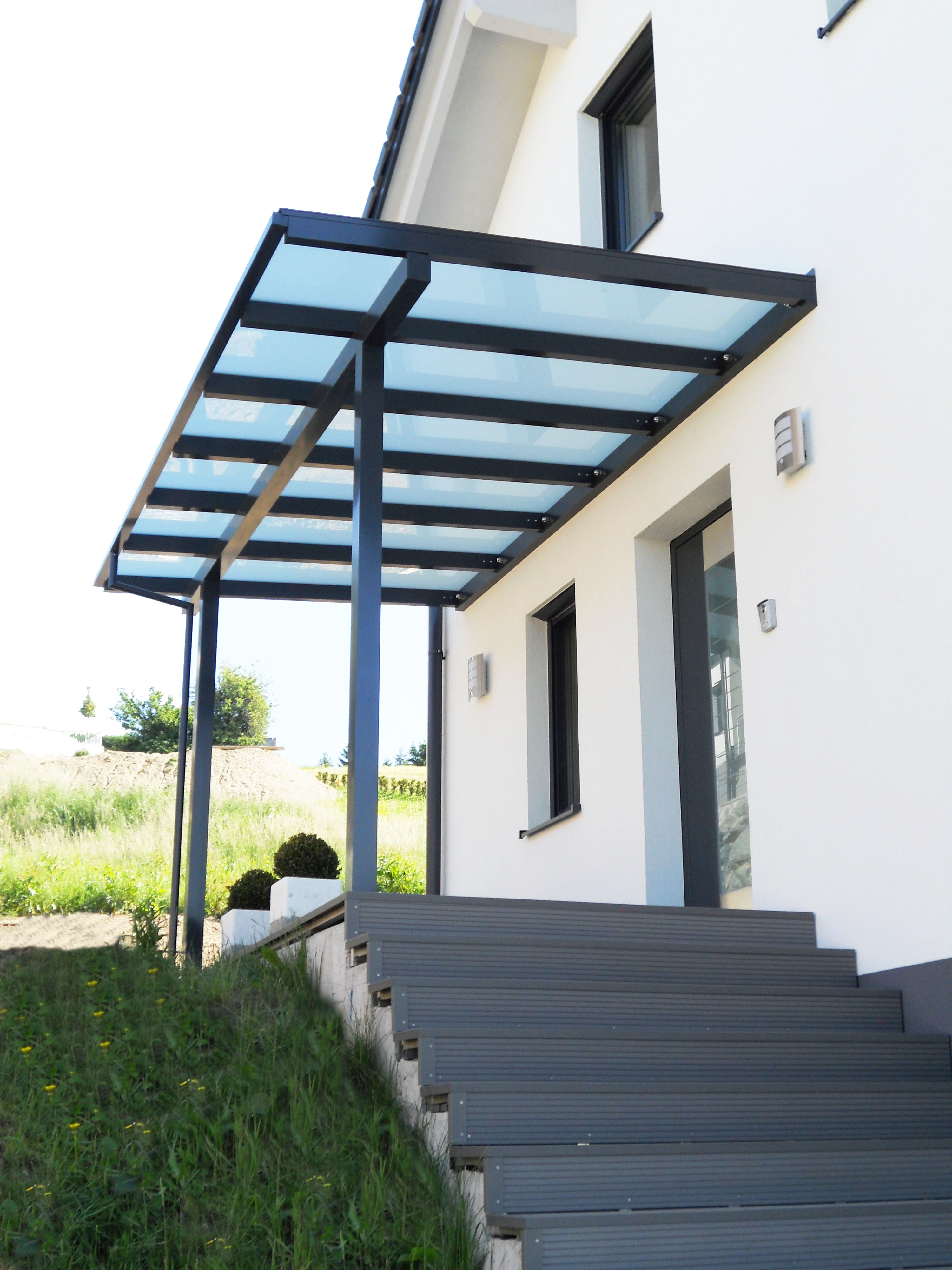 Vordach in Anthrazit mit lichtdurchlässiger Windschutzwand