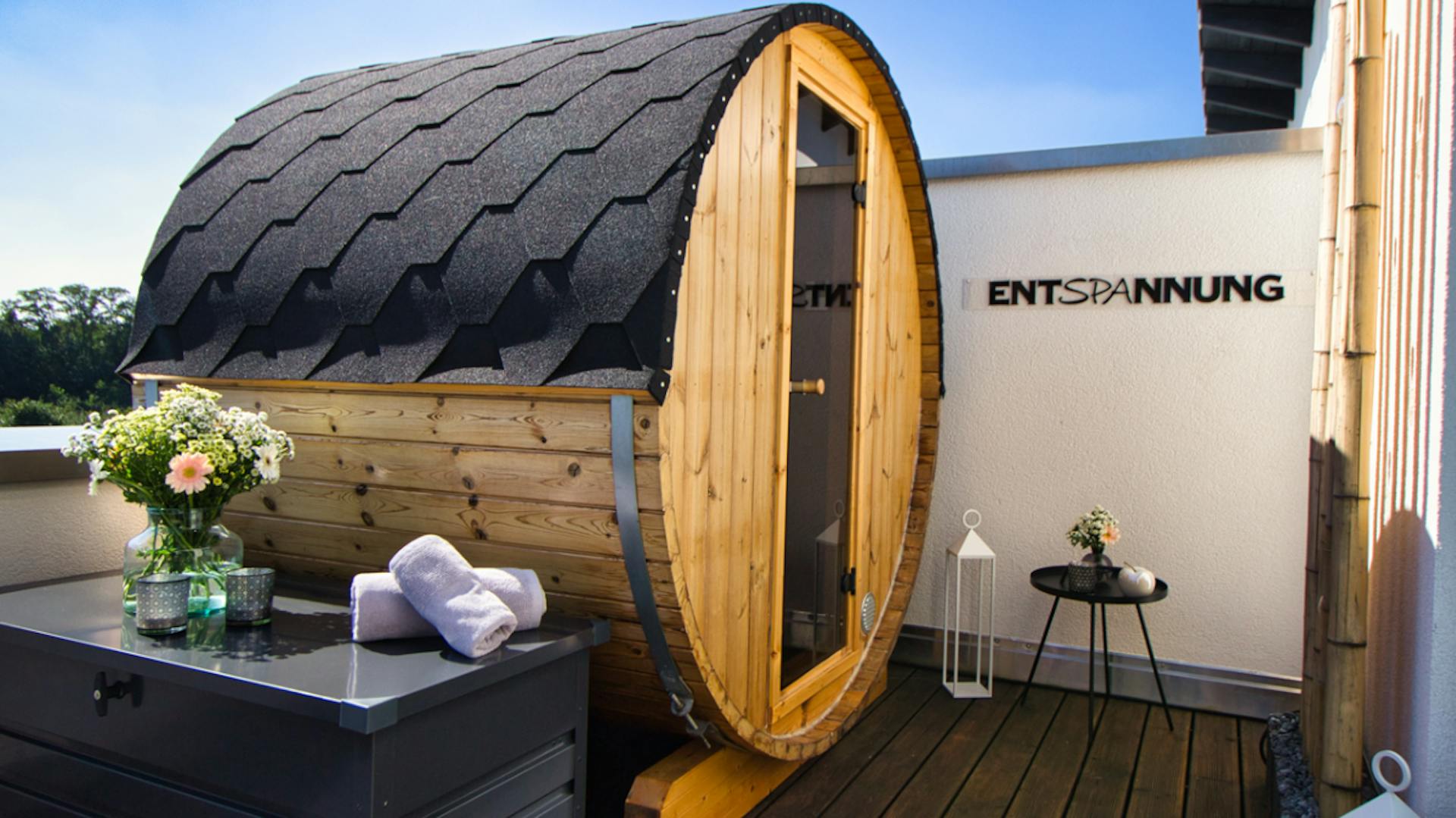 Fasssauna auf einem Balkon mit einer Glastür