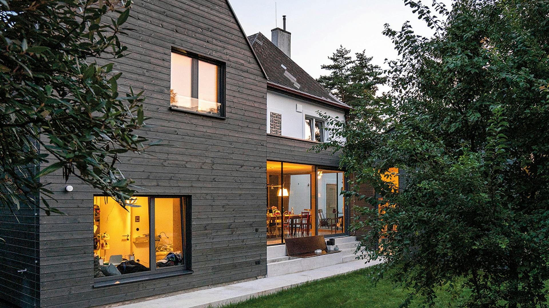 Ein Fenster in einem modernen Neubau bei Abenddämmerung, das sanftes Abendlicht einfängt.