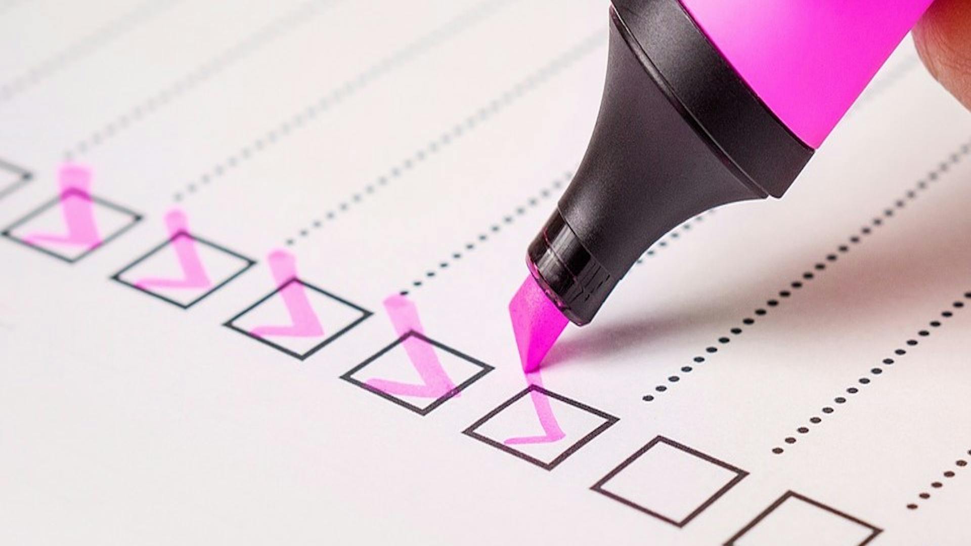 Hand hakt mit Textmarker Checkliste ab.