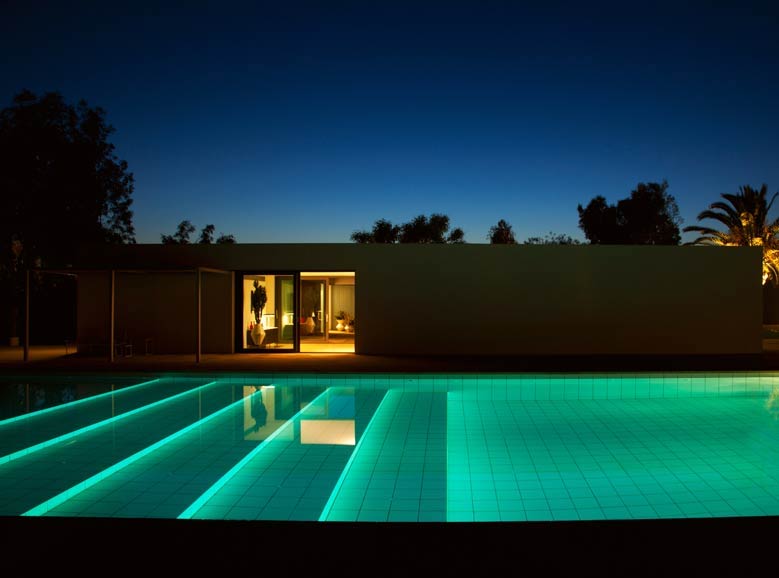 Beleuchteter Pool mit Treppe.