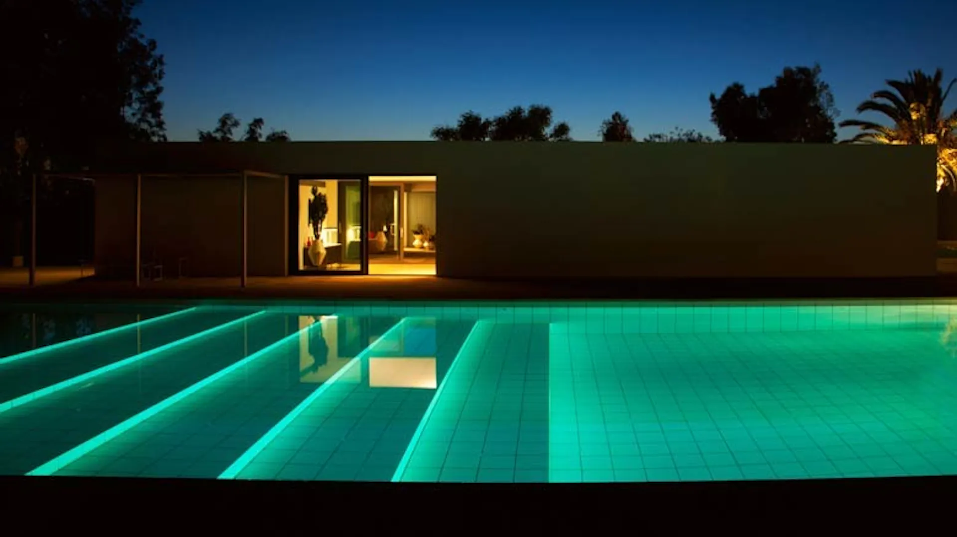 Beleuchteter Pool mit Treppe.