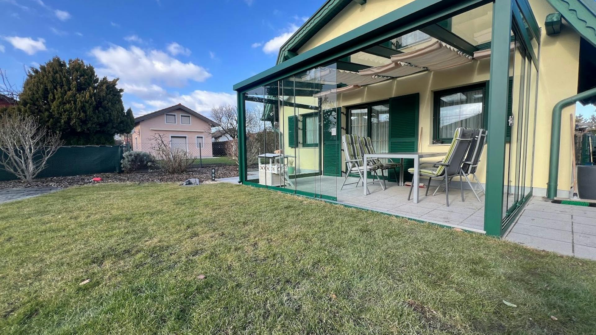 Sommergarten in Moosgrün mit welligem Sonnensegel