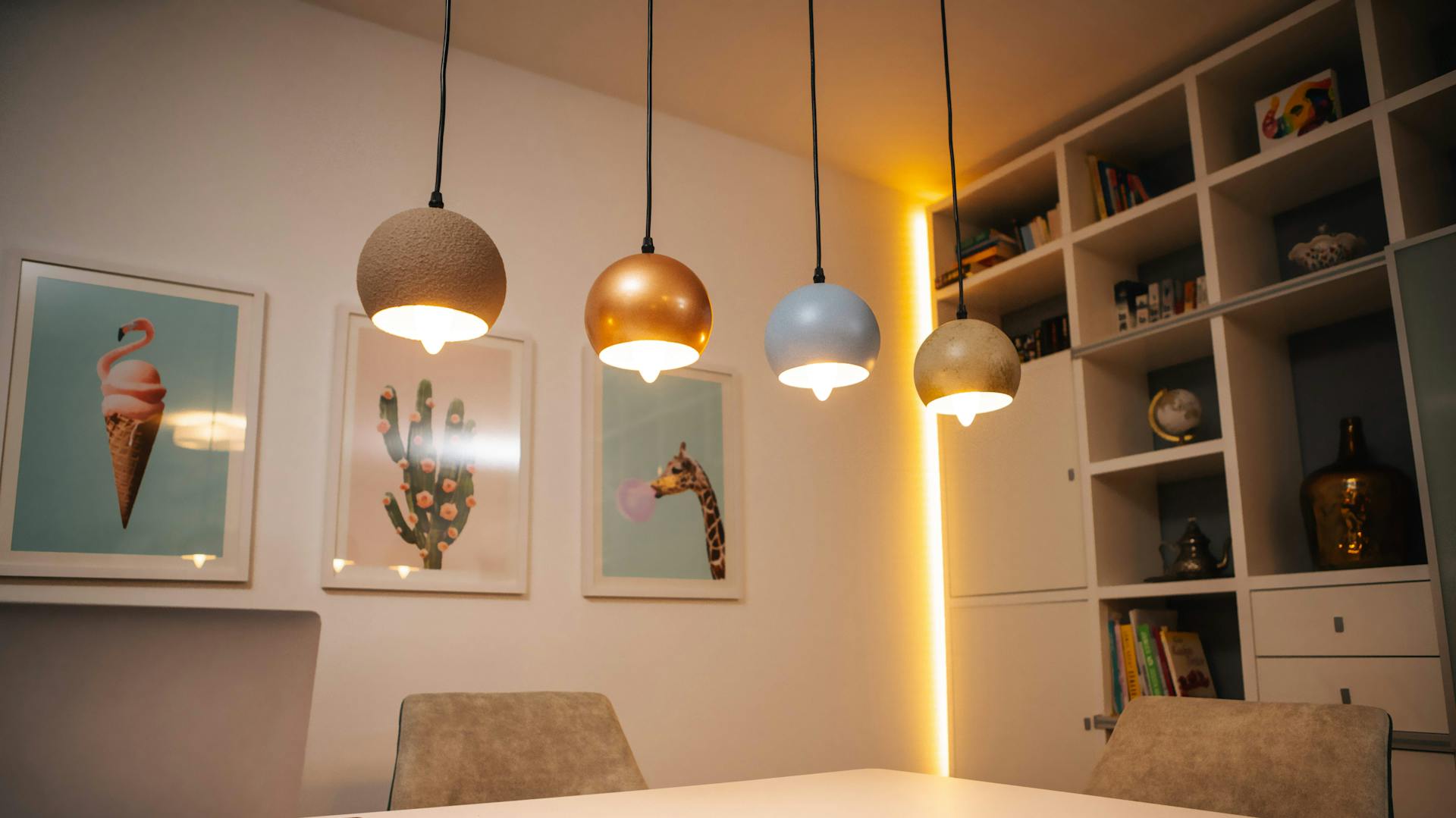 Esstisch im Raum mit Hängeleuchten und indirekter Beleuchtung am Schrank