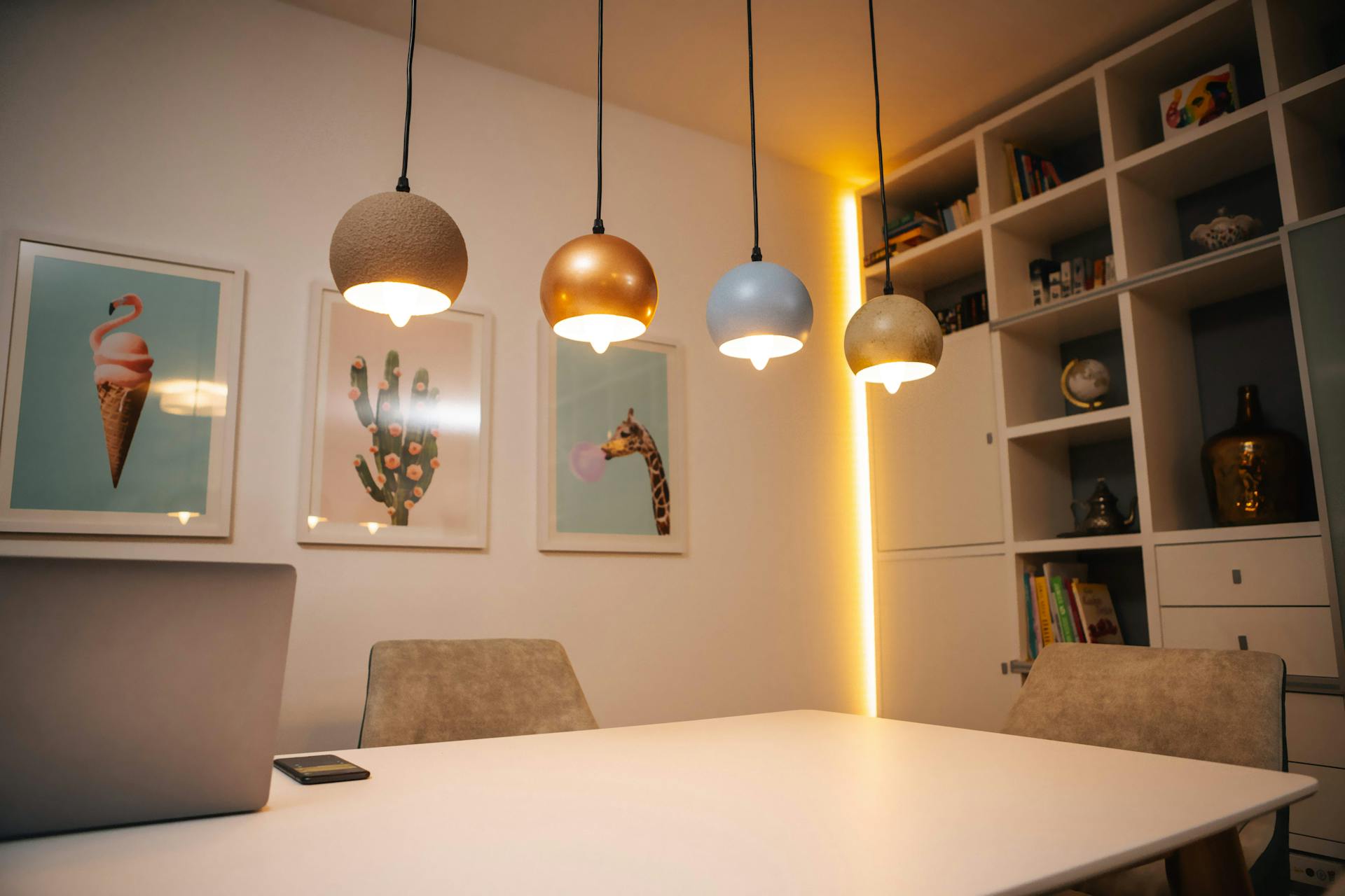 Tavolo da pranzo rettangolare in sala da pranzo, con lampade a sospensione sopra il tavolo e illuminazione indiretta sull'armadio a muro