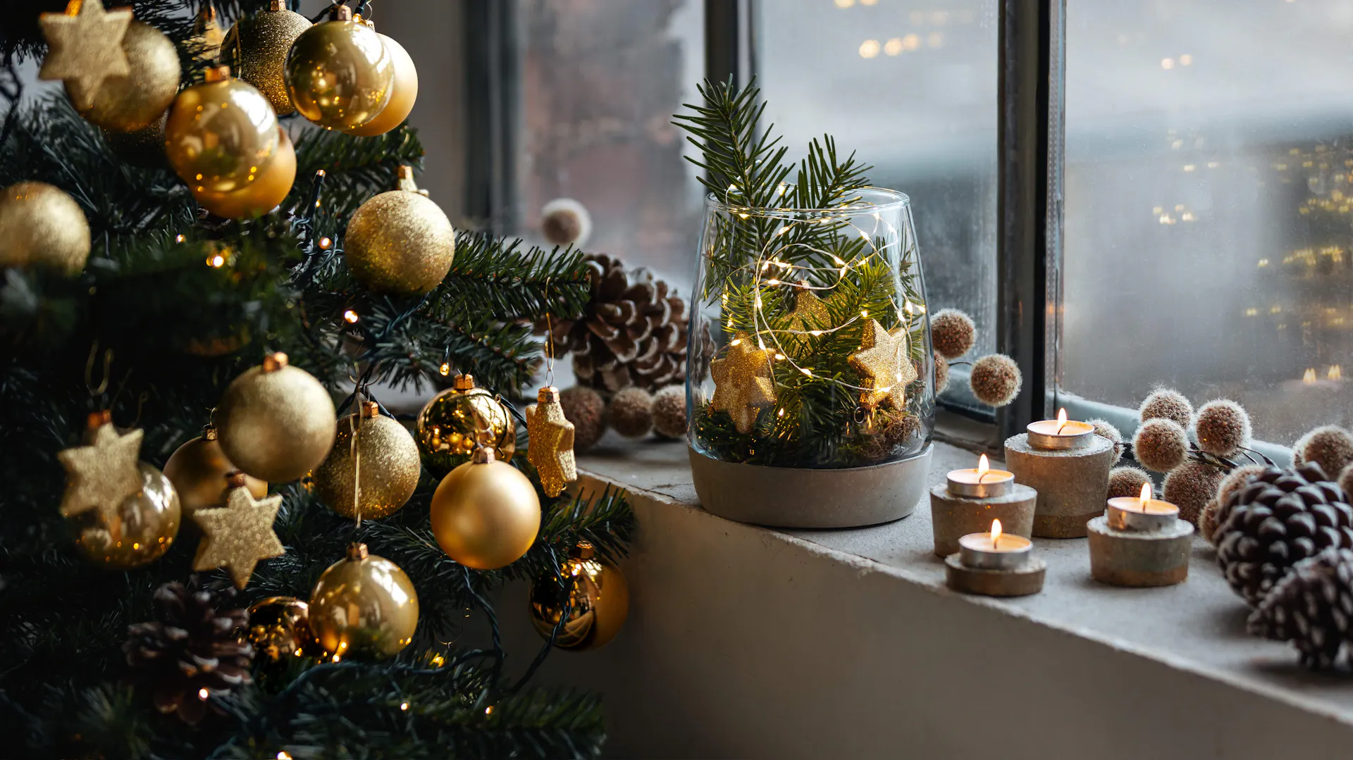 Domácí dekorace se svíčkami vedle zlatem zdobeného vánočního stromku.