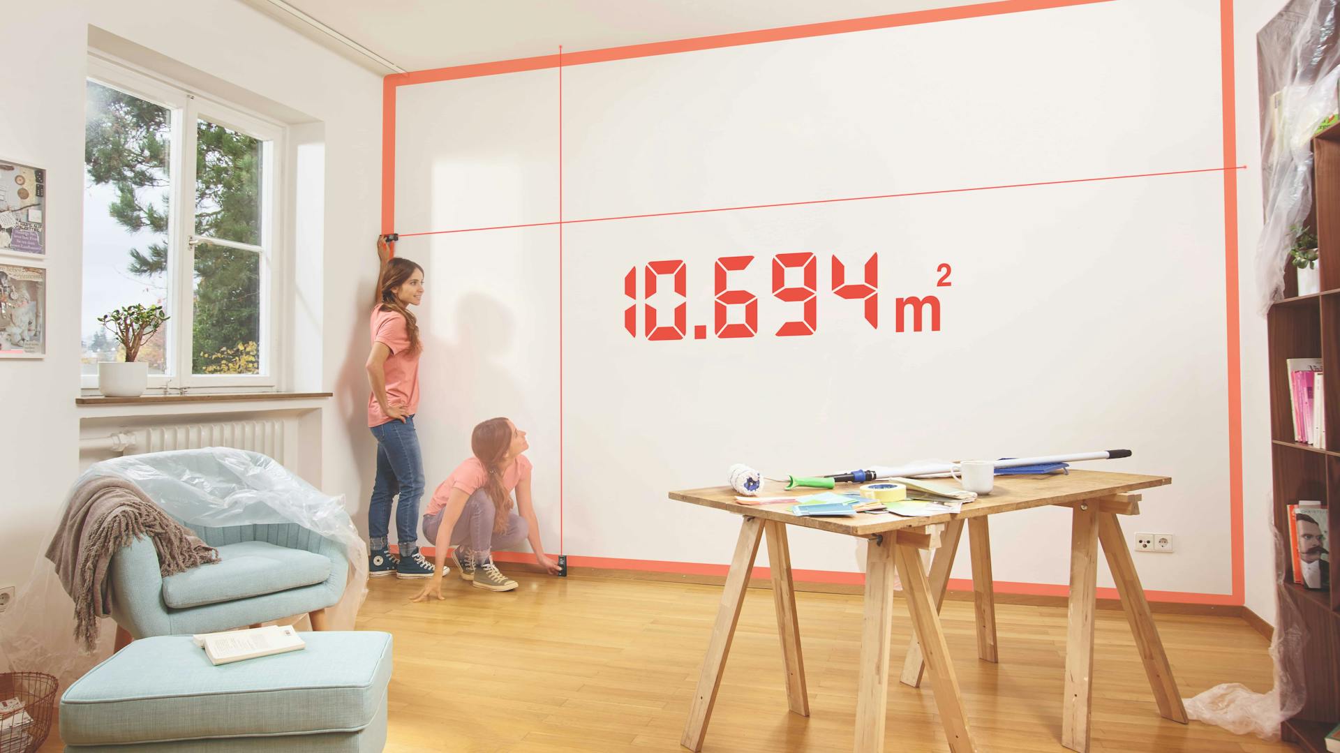 Zwei Kinder messen mit einem Bosch Messgerät eine Zimmerwand aus