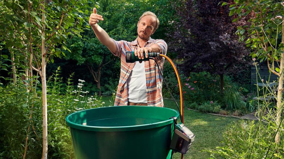 Ein Mann nutzt die Gardena GardenPump18, um Regenwasser für den Garten zu nutzen