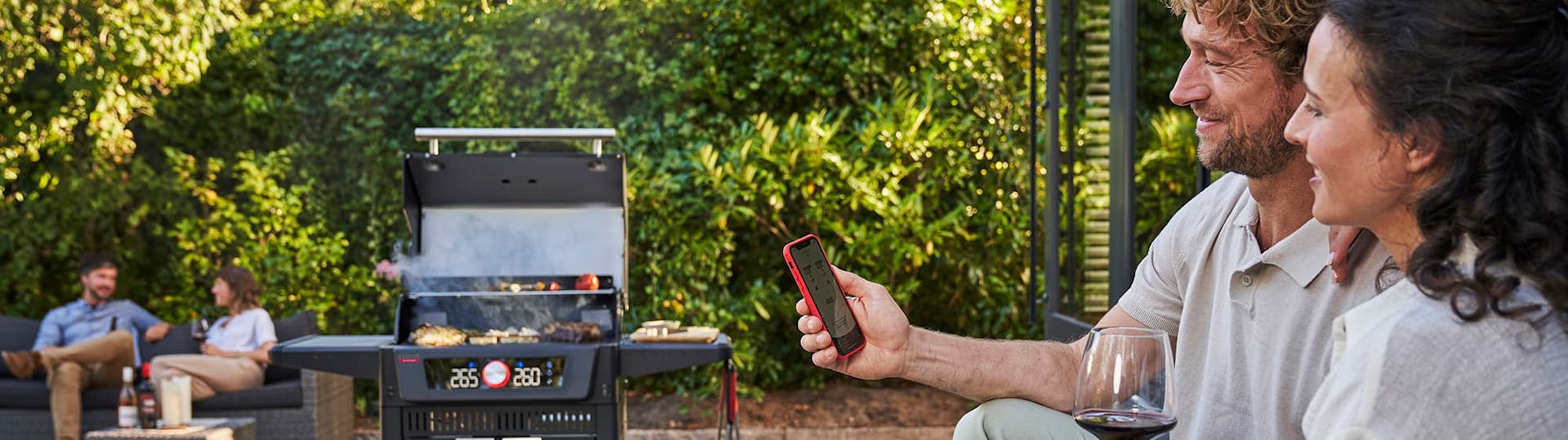 Ein Paar nutzt die App-Steuerung für den Char Broil Evolve Grill