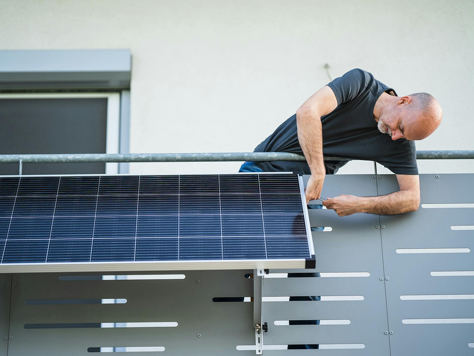 Ein Mann installiert ein Ecoflow Balkonkraftwerk