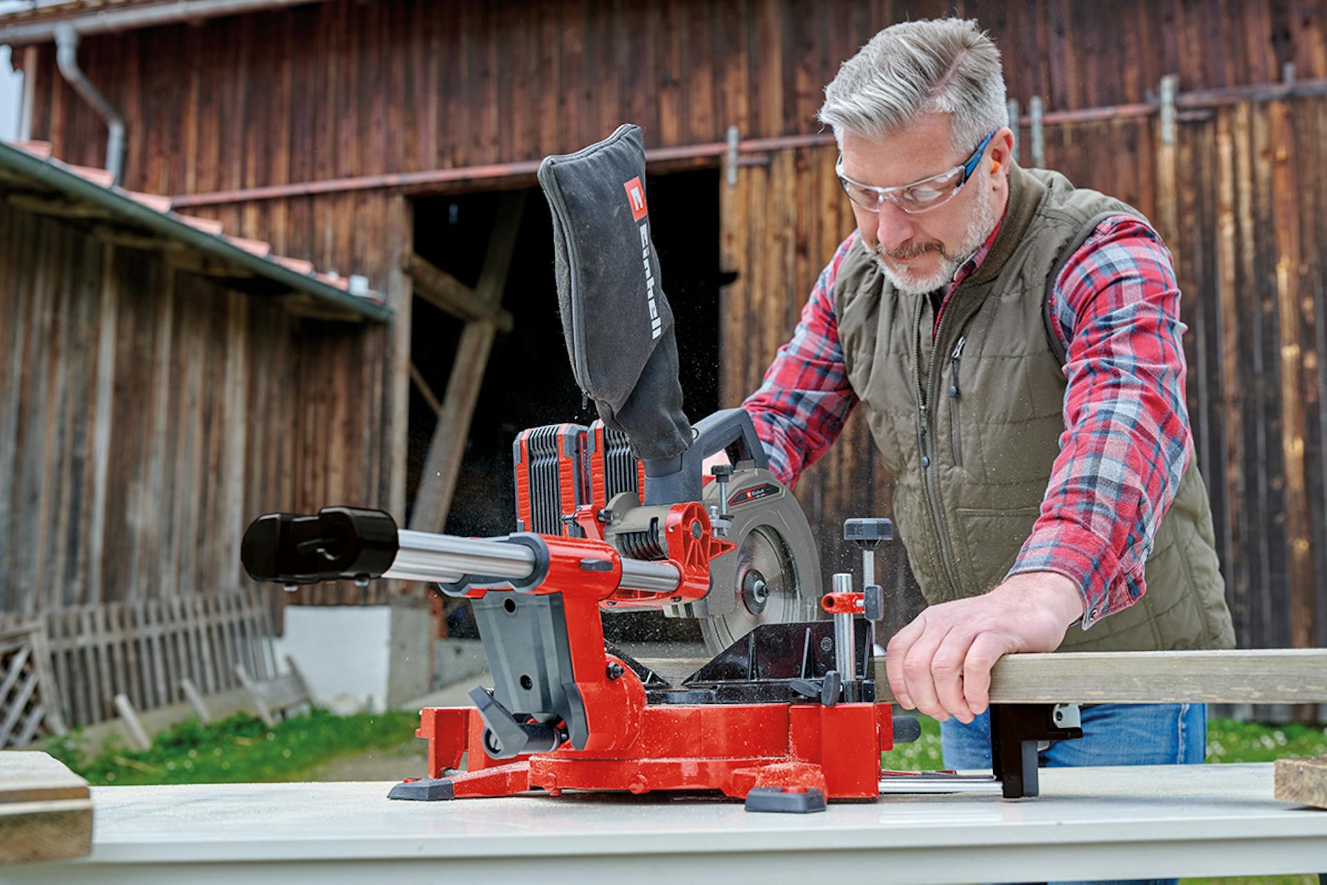 Mann sägt Holz mit Einhell Säge