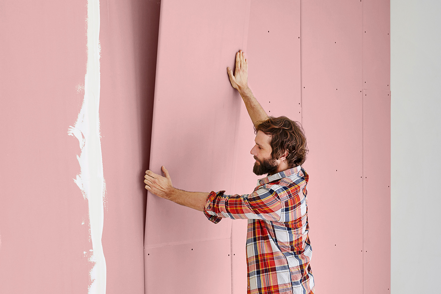 Ein Mann befestigt Gipskartonplatten