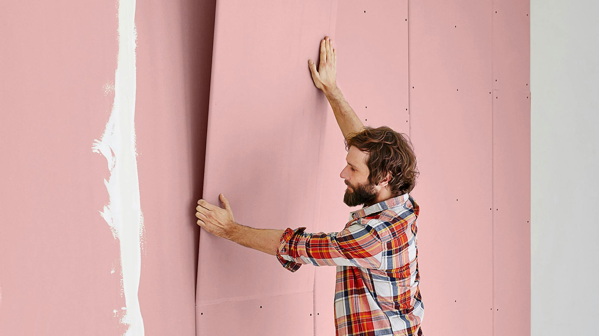 Ein Mann befestigt Gipskartonplatten