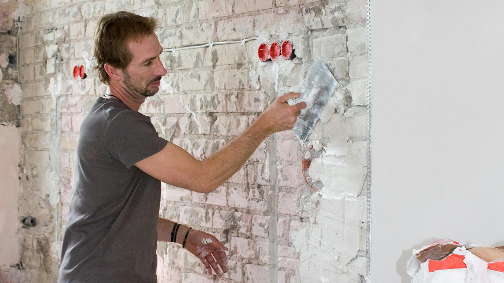 Ein Mann verputzt eine Wand mit Knauf Putz