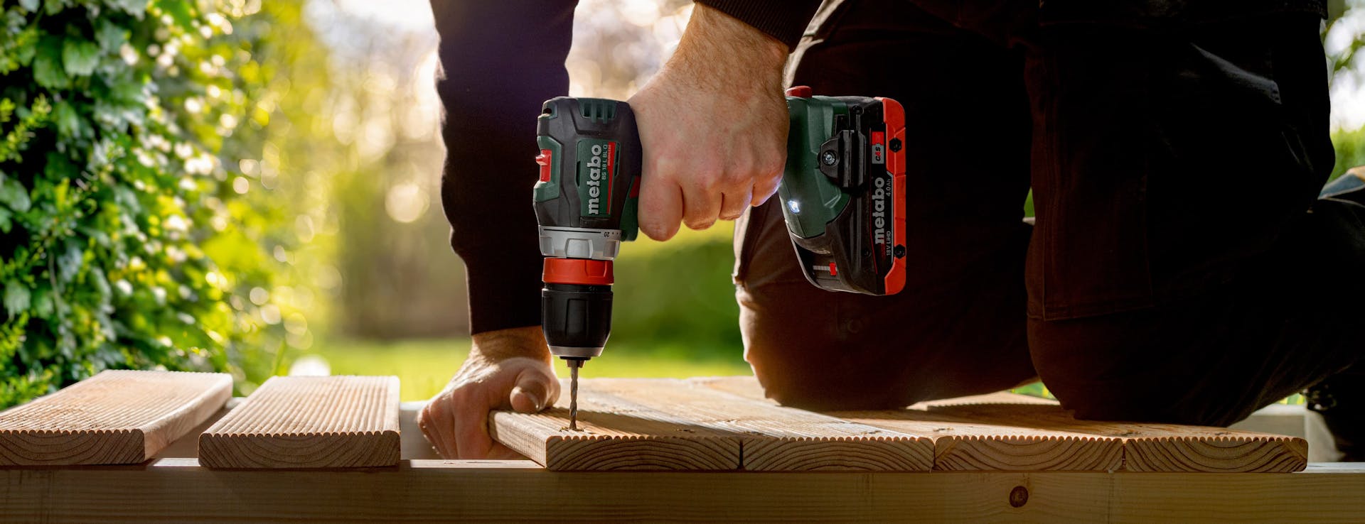 Mann schraubt Terrassendielen mit Metabo Akkuschrauber fest