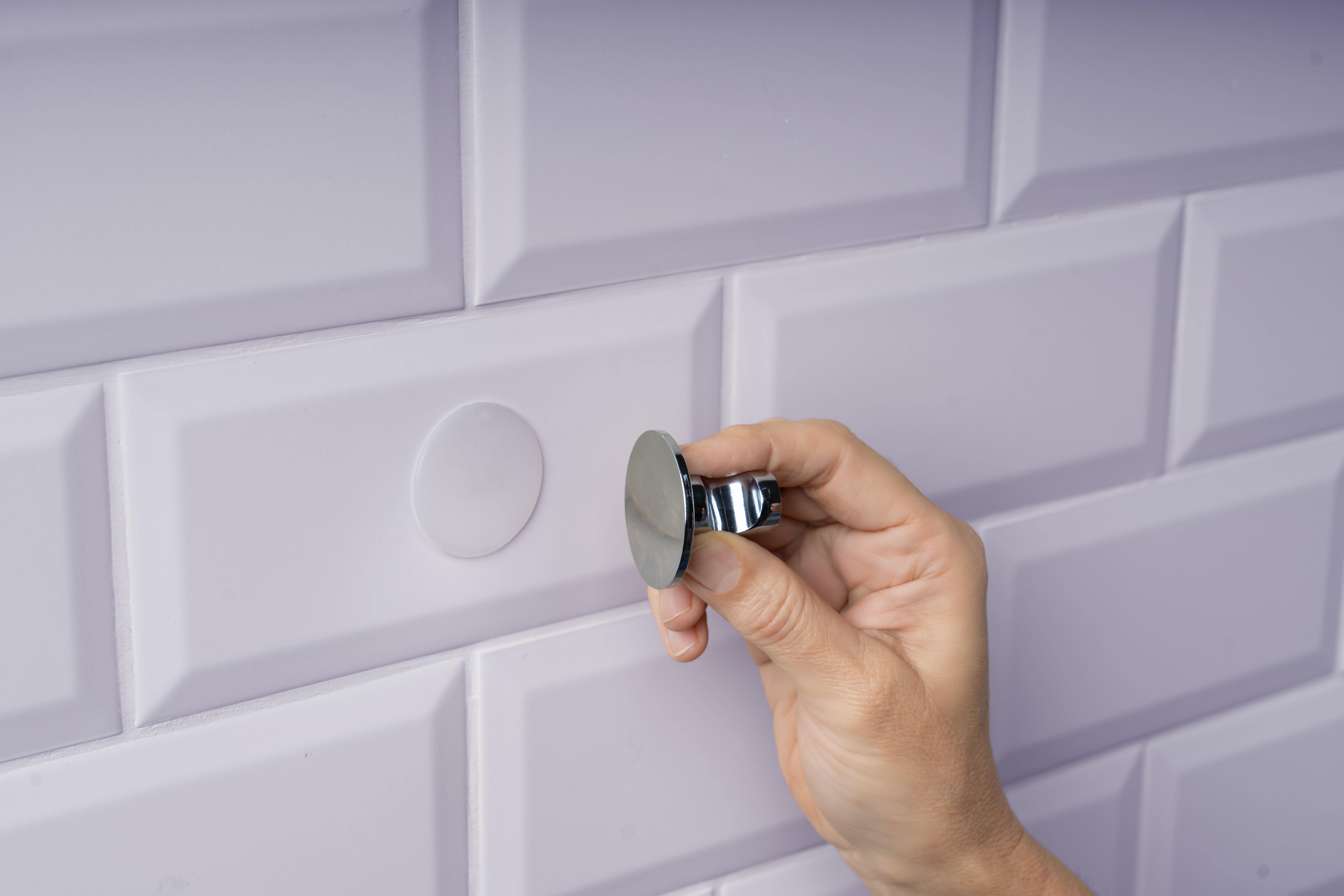 Ein Haken wird von Fliesen entfernt