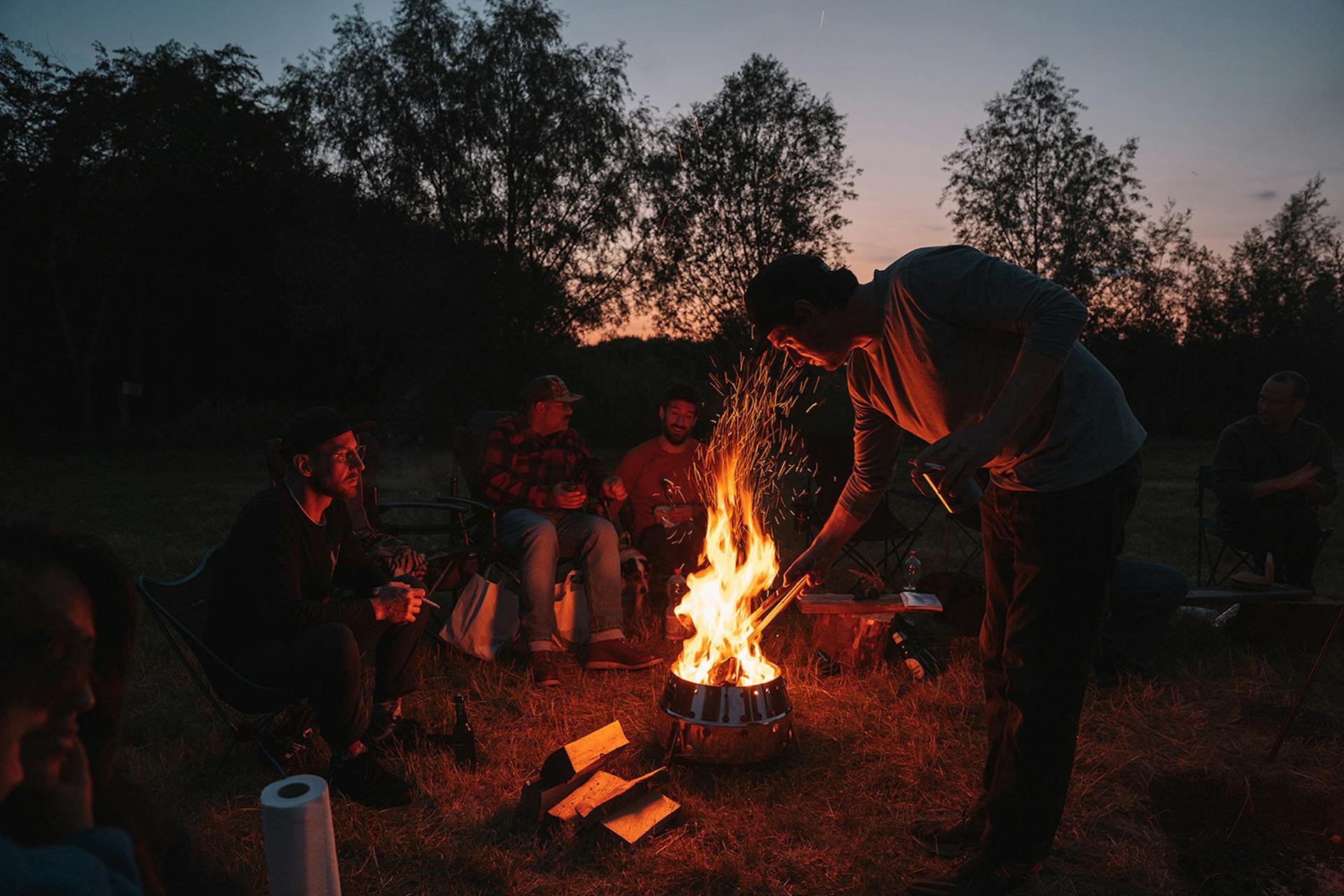 Eine Freundesgruppe macht Lagerfeuer mit Petromax Feuerschale