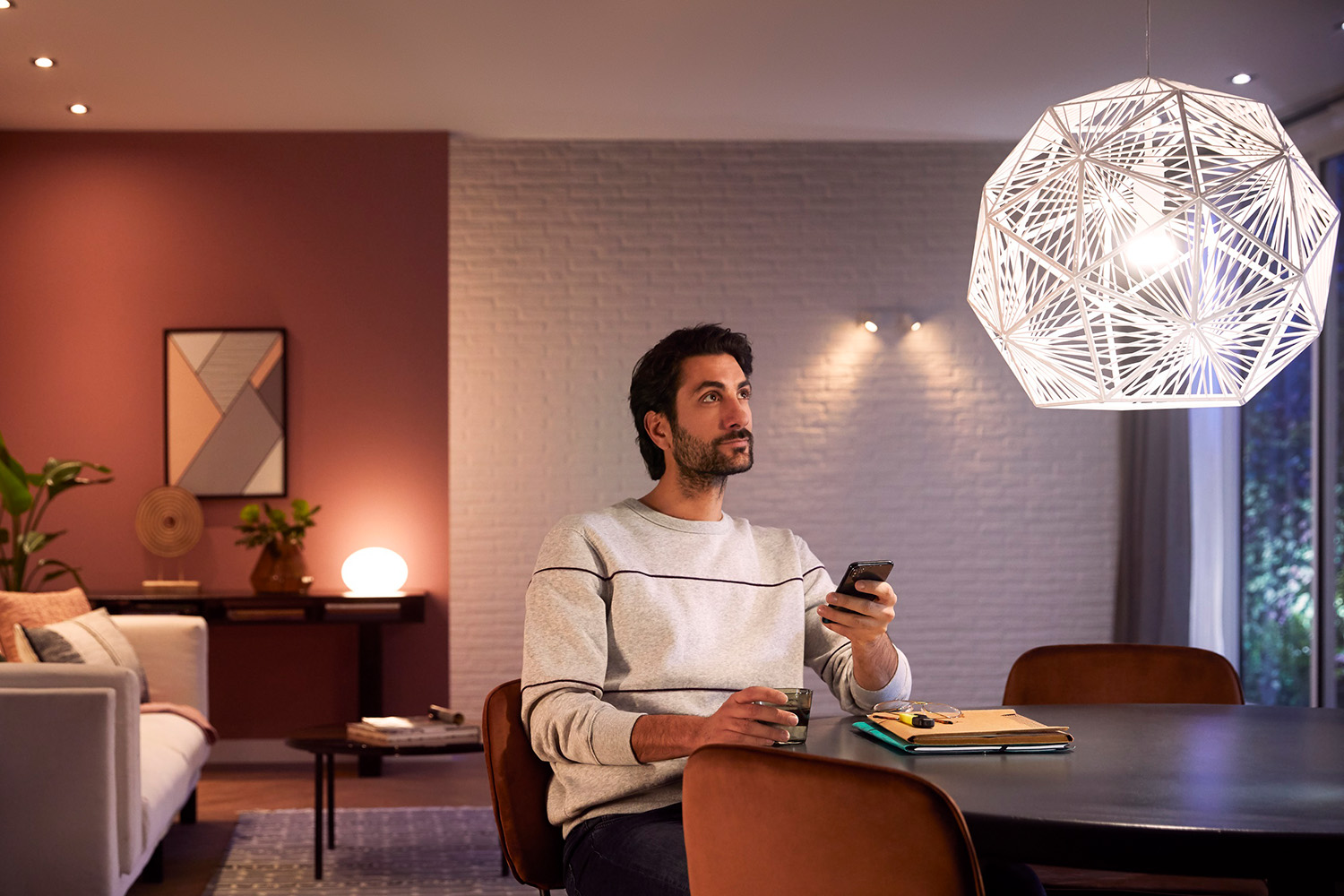 Mann steuer Philips Hue Deckenleuchte über App