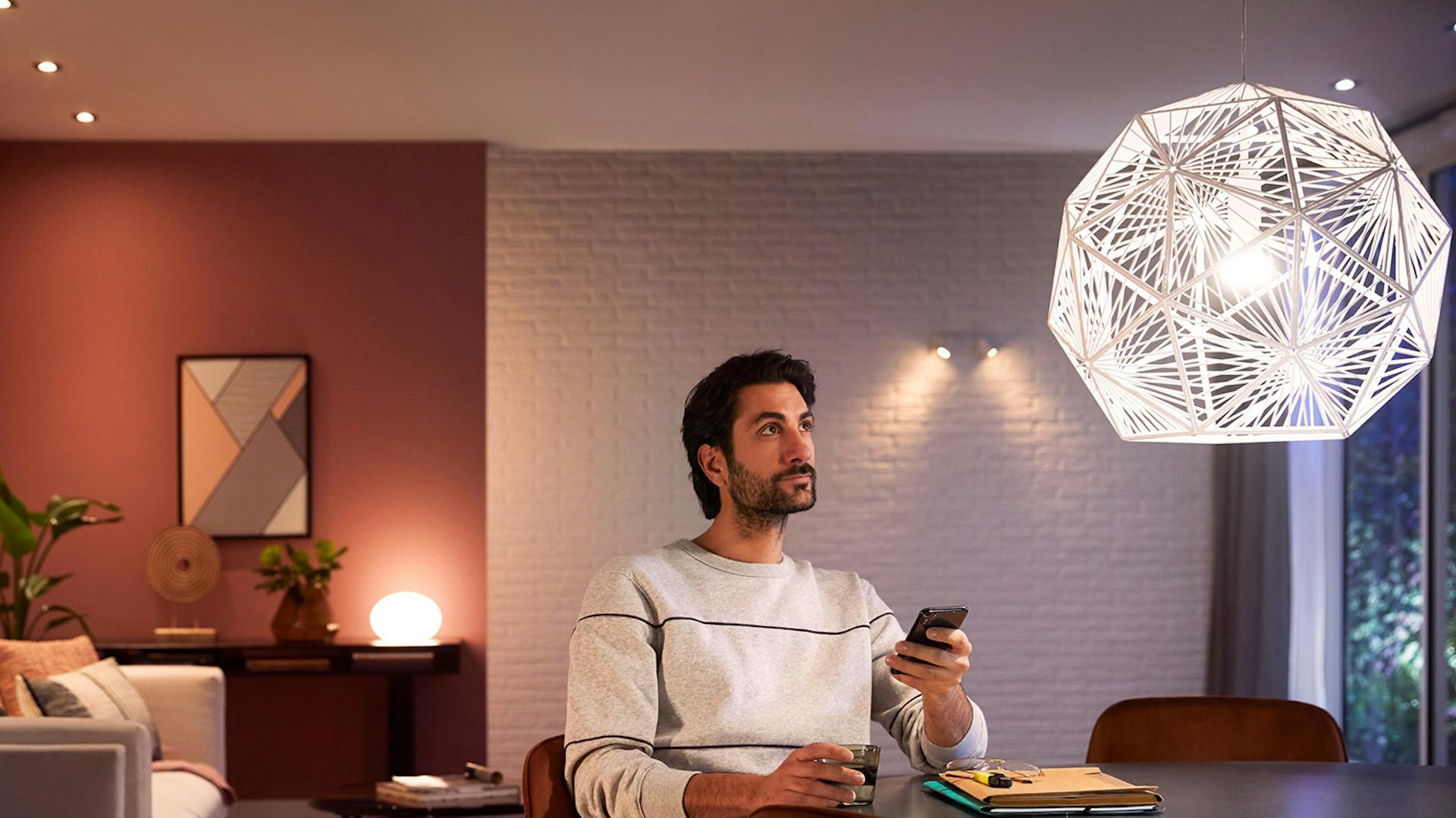 Mann steuer Philips Hue Deckenleuchte über App