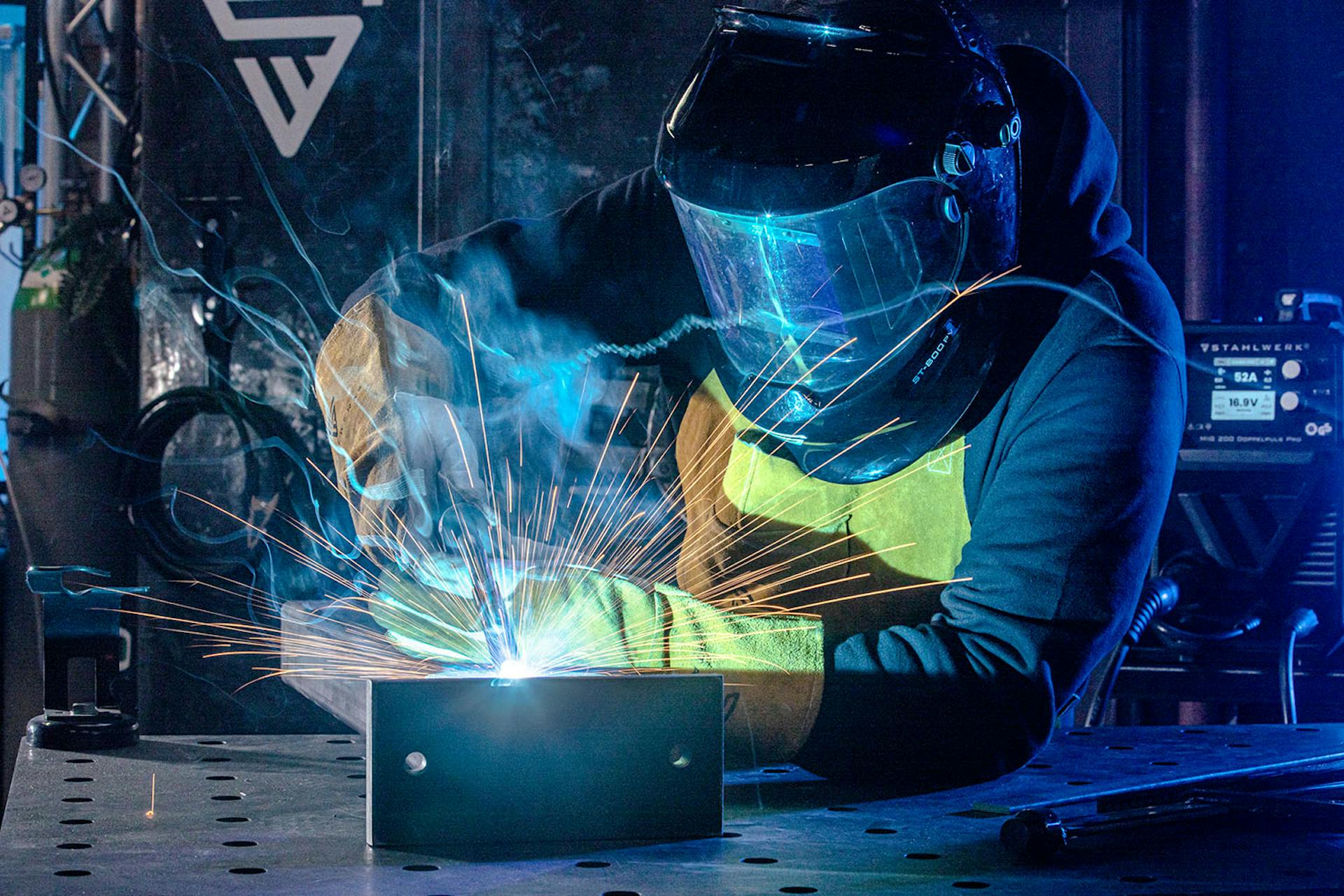 Ein Mann schweißt mit einem Stahlwerk Schweißerät