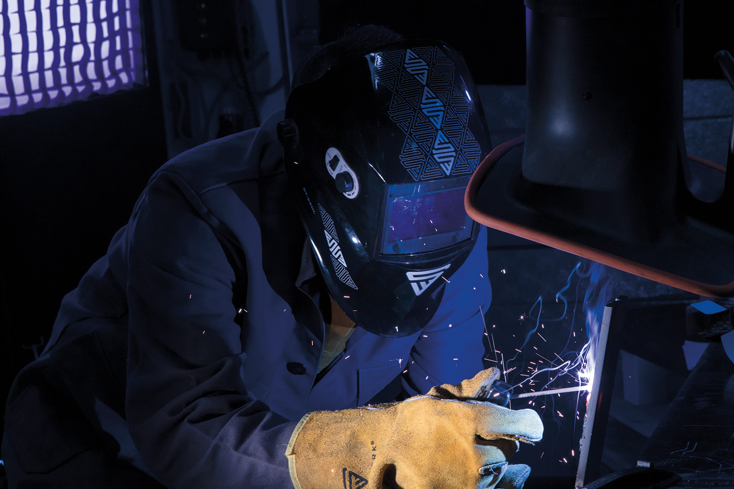 Ein Mann trägt einen Stahlwerk Schweißerhelm