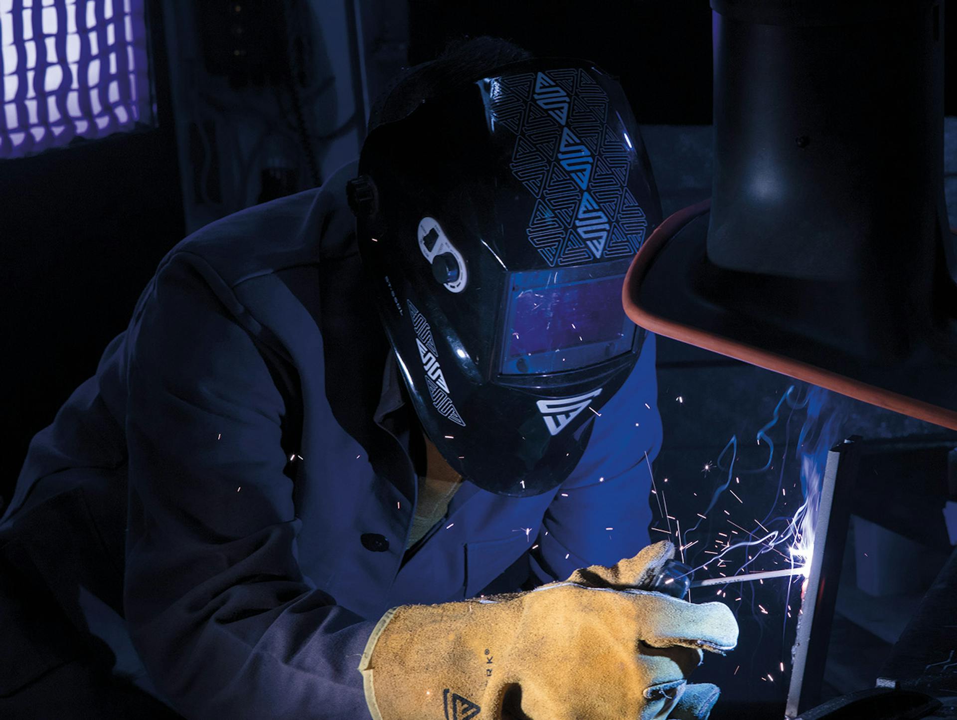 Ein Mann trägt einen Stahlwerk Schweißerhelm