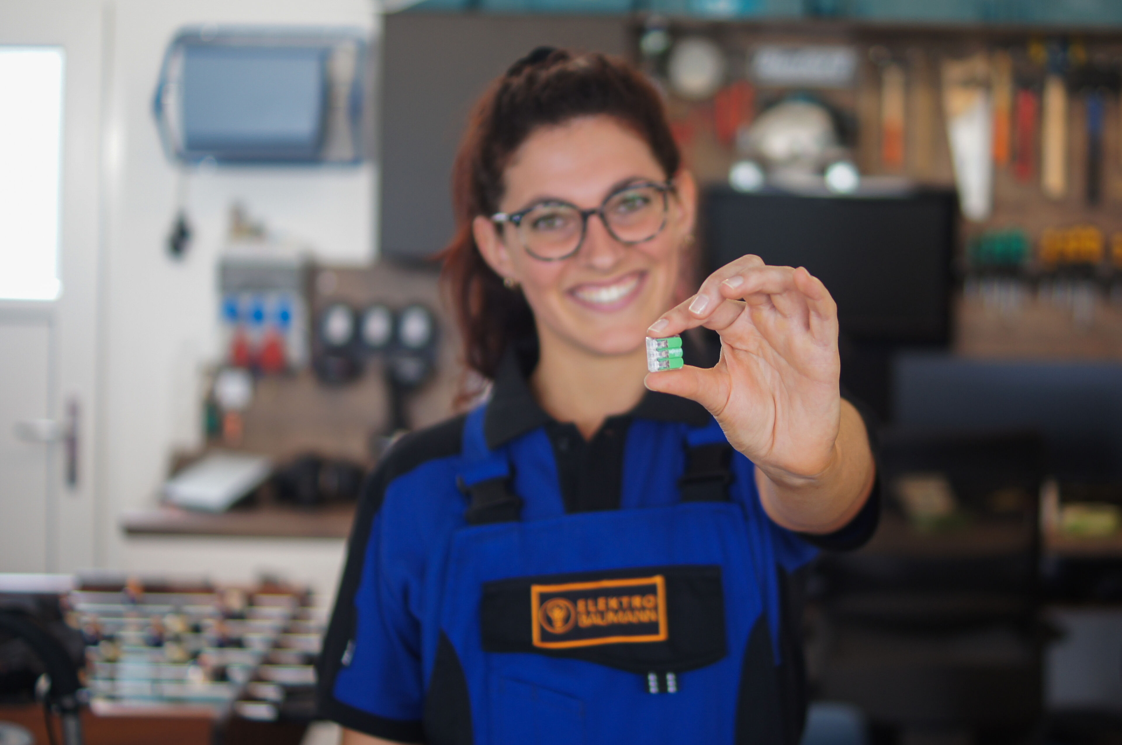 Elektrikerin mit grüner WAGO-Klemme in der Hand