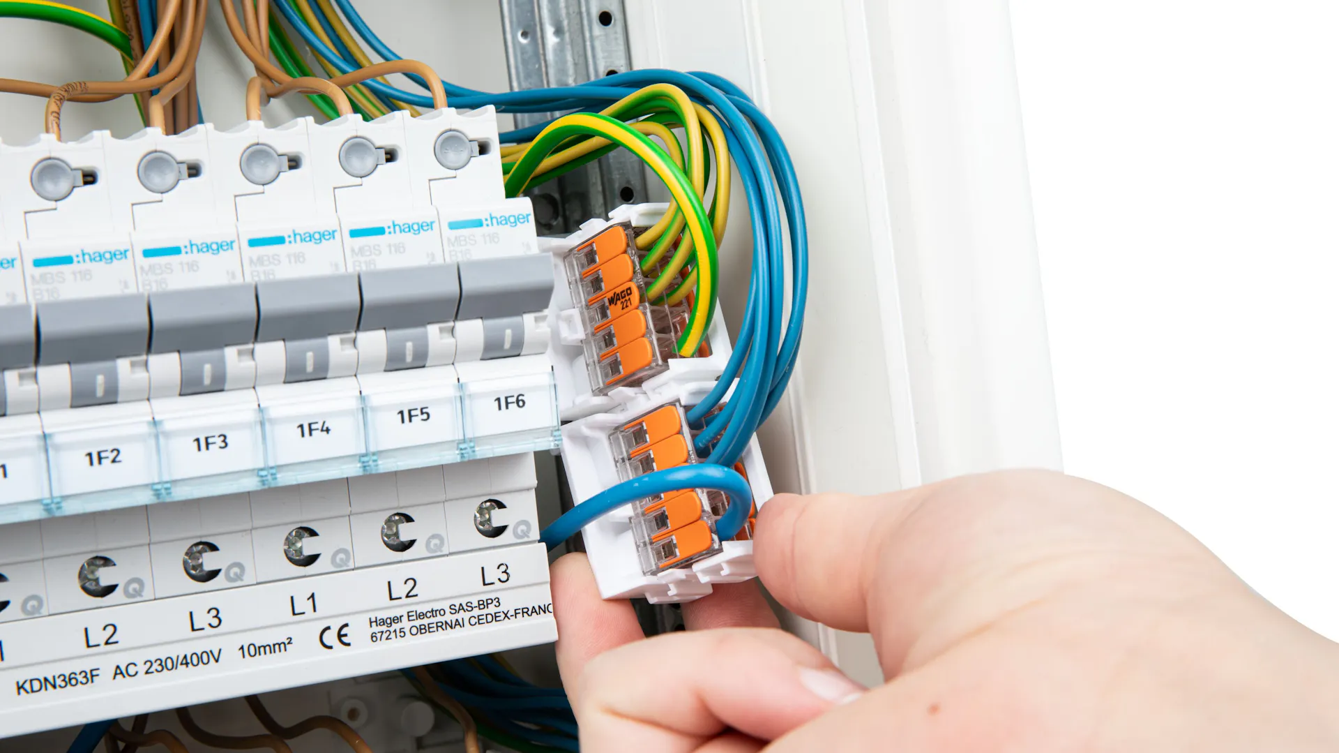 Installationsklemmen im Stromkasten werden in einer Hand gehalten