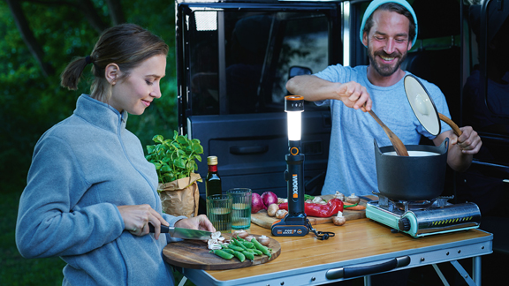 Ein Paar kocht beim Camping mit Worx Akku Lampe