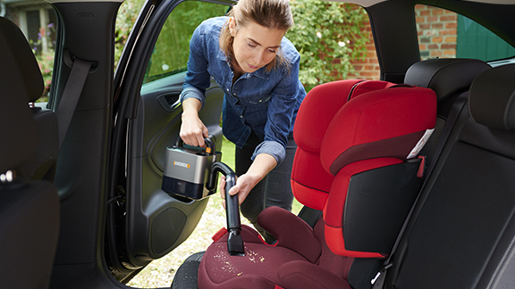 Frau reinigt Auto von innen mit Staubsauger mit Worx Akku